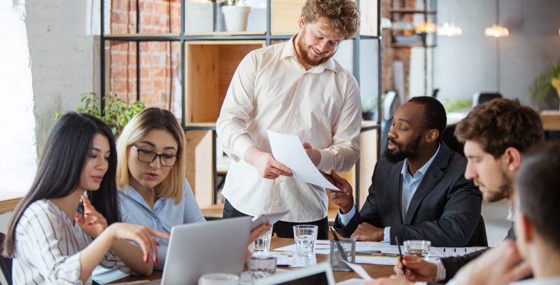 diverse-group-of-co-workers-having-casual-discussion-in-office